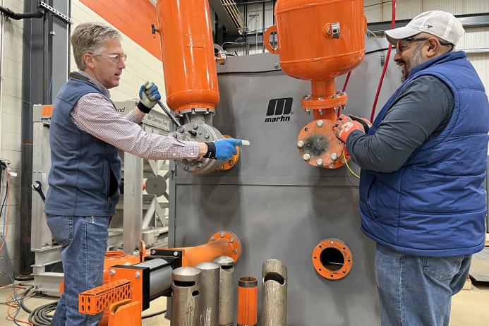 L-R: Martin Engineering business development manager Mike Masterson and product manager Sid Dev working at the air cannon test stand at the company’s Center for Innovation