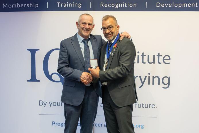 Chris Rowan (left) receiving his Long Service Medal from IQ President Ben Williams