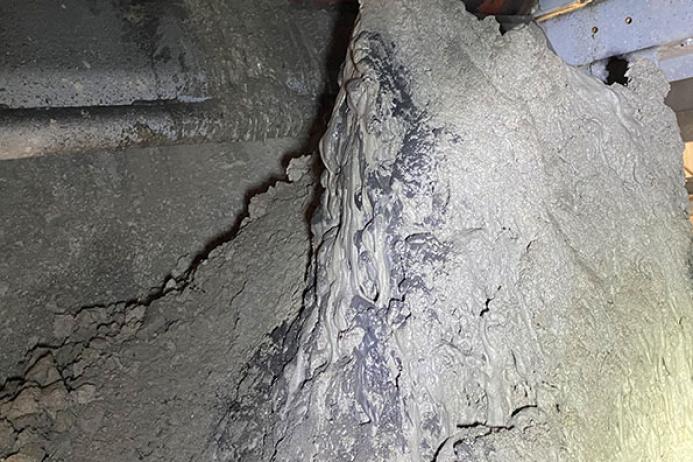 Example of incinerator bottom ash build-up under belt head drum