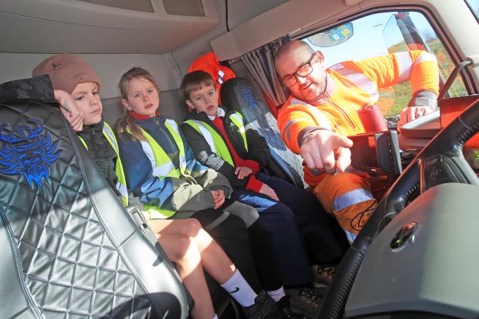 Longcliffe driver Ash Raven shows Cromford Primary School students safety technology in his lorry cab