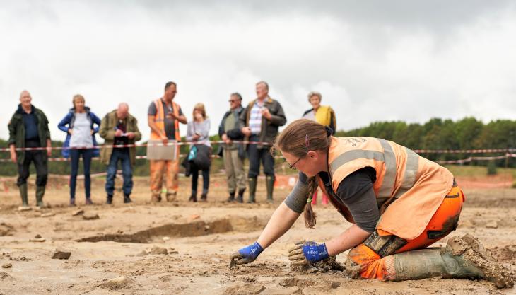 Dr Rebecca Trow of Archaeological Research Services is watched by open day visitors Dr Rebecca Trow