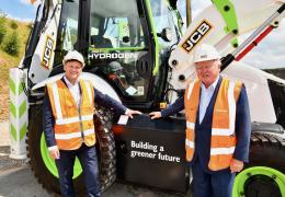 L-R: Energy Secretary Grant Shapps with JCB chairman Lord Bamford and the JCB hydrogen backhoe loader